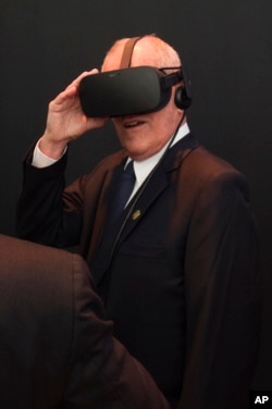 Peru's President Pedro Pablo Kuczynski tries a virtual reality headset while visiting the Facebook exhibition booth during the Asia-Pacific Economic Cooperation summit in Lima, Peru, Nov. 19, 2016.