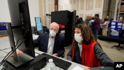 Democratic and Republican representatives review absentee ballots at the Fulton County Election preparation Center, Nov. 4, 2020 in Atlanta. 