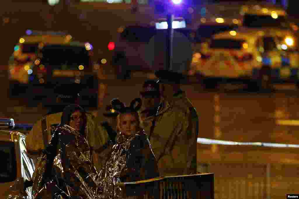 Two women wrapped in thermal blankets look on near the Manchester Arena, where U.S. singer Ariana Grande had been performing, in Manchester, northern England, Britain, May 23, 2017