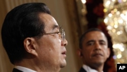 U.S. President Barack Obama looks on as Chinese President Hu Jintao speaks during a joint news conference in the East Room of the White House in Washington, 19 Jan 2011