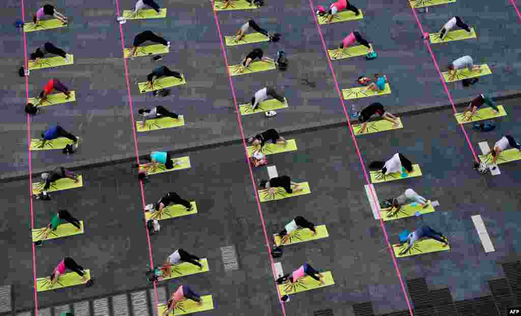 Yogis take part in “Solstice in Times Square: Mind Over Madness Yoga,” an annual all-day outdoor yoga event in Times Square in New York, to celebrate the summer solstice and the re-awakening of the city.