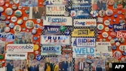 FILE - Campaign slogans, buttons, stickers and memorabilia of U.S. presidential candidates, past and present, some autographed, decorate a walls of the visitor center at the State House in Concord, New Hampshire, Feb. 3, 2020.