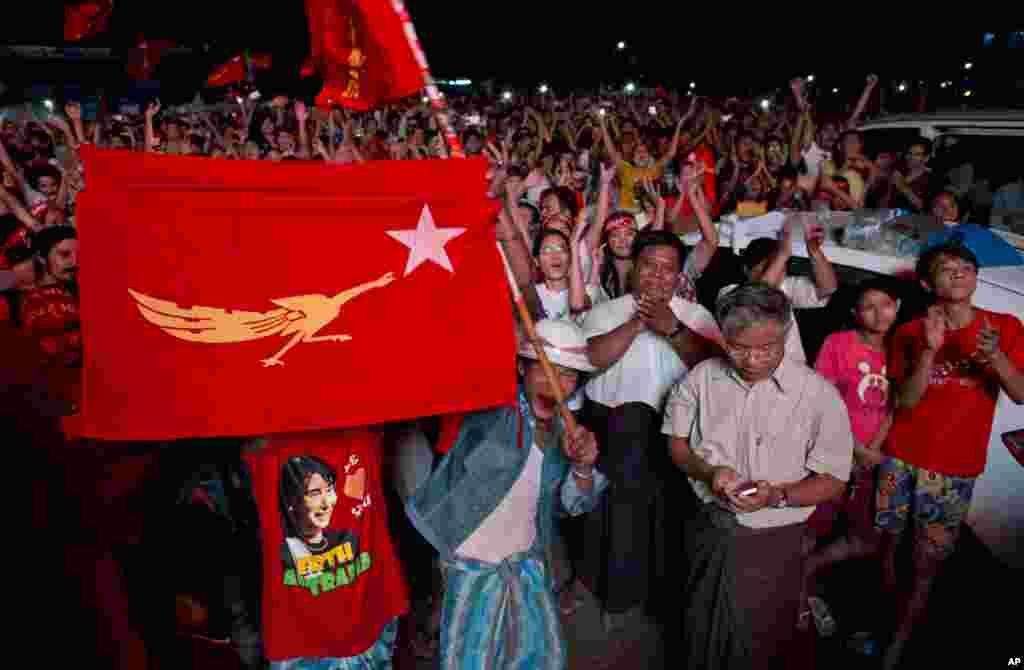 Para pendukung partai Liga Nasional Myanmar untuk Demokrasi (NLD) merayakan hasil pemilihan umum yang ditempel di luar kantor pusat partai di Yangon, Myanmar (9/11). (AP/Gemunu Amarasinghe)