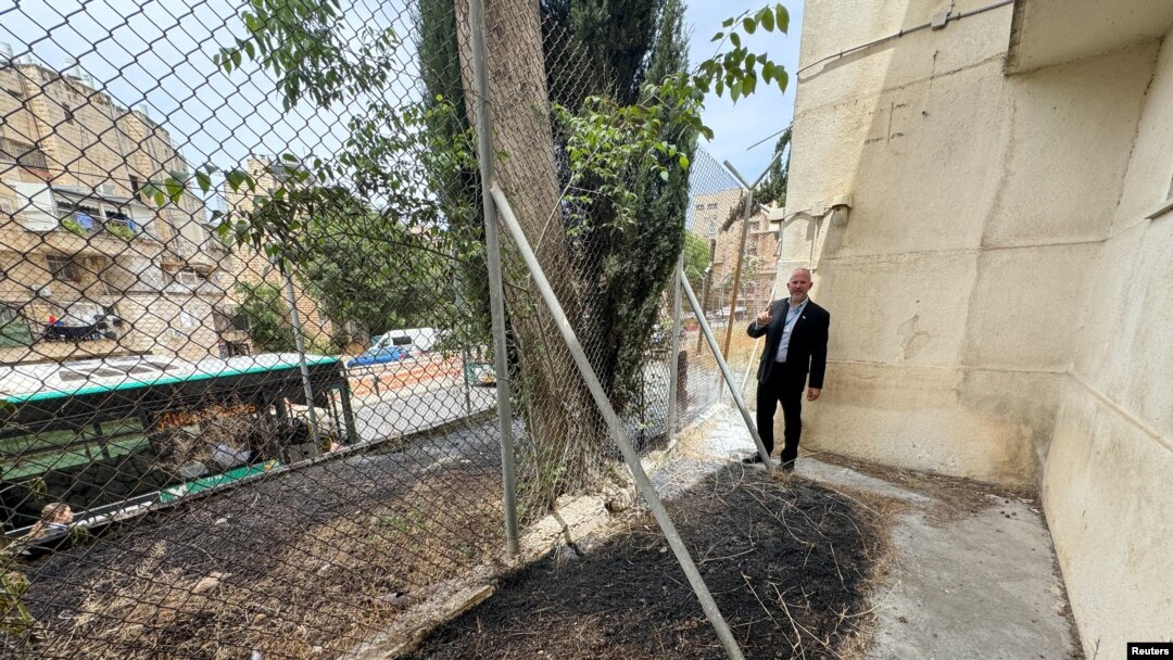 El personal de la Agencia de las Naciones Unidas para los Refugiados de Palestina (UNRWA) revisa su sede en Jerusalén Oriental, donde son visibles los rastros de un incendio en el perímetro del edificio el 10 de mayo de 2024.