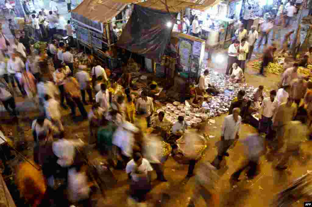 March 31: Vendors display as commuters walk past in Kolkata, India. (AP Photo/Bikas Das)