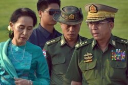 FILE - Aung San Suu Kyi, left, Myanmar's foreign minister, walks with senior General Min Aung Hlaing, right, Myanmar military's commander-in-chief, in Naypyitaw, May 6, 2016.