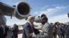 South Sudanese Foreign Minister Barnaba Marial Benjamin, right, welcomes US Secretary of State John Kerry at Juba International Airport, Friday May 2, 2014. On Tuesday, the United States imposed sanctions on two South Sudanese military leaders, one from each side of the conflict.