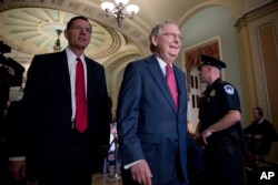 Senate Majority Leader Mitch McConnell of Kentucky, right, accompanied by Sen. John Barrasso of Wyoming, leaves a Senate Republican conference leadership election meeting on Capitol Hill in Washington after being re-elected majority leader for the upcoming 115th Congress, Nov. 16, 2016.