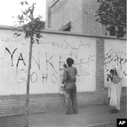 A resident of Tehran washes "Yankee Go Home" graffiti from a wall in the capital city of Iran, Aug. 21, 1953. The new Premier Gen. Fazlollah Zahedi requested the cleanup after the coup d'etat, which restored the Shah of Iran in power.