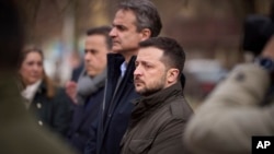 In this photo provided by the Ukrainian Presidential Press Office, Ukrainian President Volodymyr Zelenskyy, center right, and Greece's Prime Minister Kyriakos Mitsotakis visit a place of Russian attack at a residential area on March 2, in Odesa, March 6, 2024.