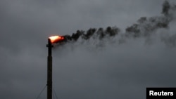 FILE - Smoke rises from a burn off at an oil refinery in Corpus Christi, Texas, on Aug. 26, 2017. Oil production in the United States rose to a record 13.46 million barrels per day in October 2024, the U.S. Energy Information Administration said on Dec. 31, 2024.