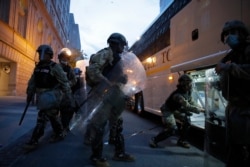Soldiers with the District of Columbia National Guard load buses to leave as demonstrators gather to protest the death of George Floyd, June 3, 2020, in Washington.