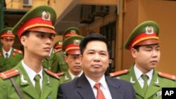 Cu Huy Ha Vu is escorted by policemen after his trial at a court in Hanoi April 4, 2011. Vu, a legal scholar who sued Vietnam's prime minister and called for an end to one-party rule, was sentenced on Monday to seven years in prison in one of the Communis