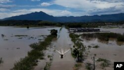 Residentes cruzan una carretera sumergida en un bote después de una lluvia mortal en Duque de Caxias, Brasil, el 15 de enero de 2024.