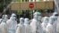Police officers wearing protective suits gather outside an apartment under enhanced lockdown to pick up illegal immigrants, due to the outbreak of the coronavirus disease (COVID-19), in Kuala Lumpur, Malaysia, May 1, 2020. 