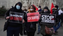 FILE - Activists hold placards reading 'Islamophobia is enough' and 'Stop Zemmour', Feb. 14, 2021, in Paris.