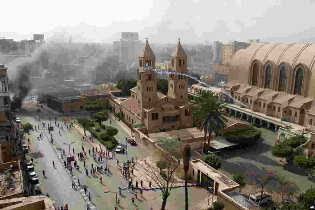Egyptian riot police fire tear gas into the compound of the Coptic Orthodox Cathedral after the funeral of four Christians killed in sectarian clashes near Cairo, April 7, 2013. 