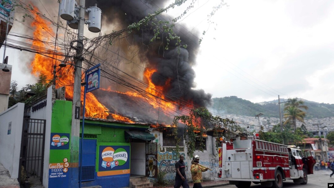 A building burns, set afire by protesters in Port-au-Prince, Haiti, Sept. 27, 2019. Thousands seeking to oust President Jovenel Moise attacked businesses and government buildings across Haiti, fed up with a lengthy shutdown of vital services.