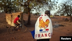 FILE - A man wears a French flag to show support for the French military intervention in Mali, in the capital, Bamako, Jan. 14, 2013. Coups in half a dozen former French colonies in Africa over the past three years are sparking soul searching about France's relations with Africa.