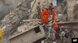 Rescue workers carry the body of a victim after a building collapsed in Rio de Janeiro, Brazil, Jan. 26, 2012.