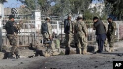 Afghan policemen investigate at the site of a suicide bomb attack in Nangarhar province, March 5, 2012