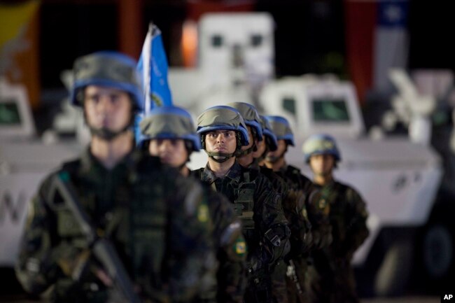 FILE - United Nations peacekeepers from Brazil stand at attention during the end of operations ceremony of the Brazilian battalion and engineering company, from the United Nations Stabilization Mission in Haiti, in Port-au-Prince, Aug. 31, 2017.