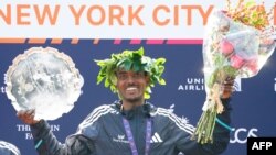 Ethiopia's Tamirat Tola poses on the podium after winning the 52nd Edition of the New York City Marathon, Nov. 5, 2023.