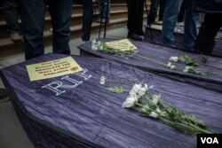 Four coffins were laid in front of New York's City Hall, representing the recent suicides of four professional drivers. (R. Taylor/VOA)