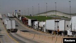 Trucks wait in a long queue for border customs control to cross into the U.S. at the Otay border crossing in Tijuana, Mexico, Feb. 2, 2017.