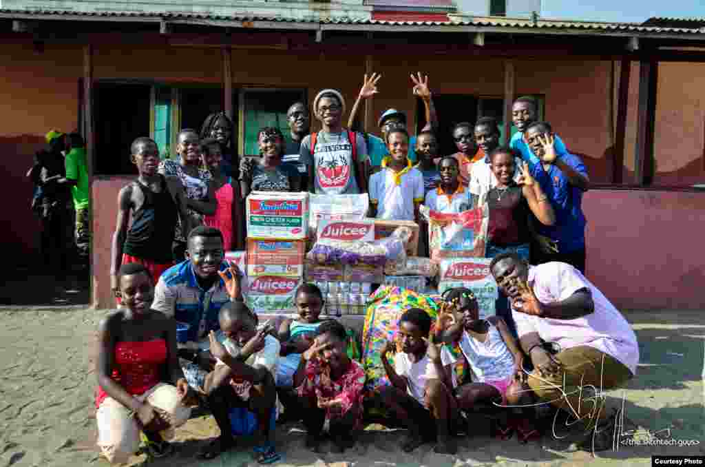 Boys and girls from suburban Accra&#39;s M&#39;adamfo Pa Orphanage crowd around clothes and cases of soft drinks presented by several members of Team Tiki.&nbsp;(Courtesy Team Tiki)