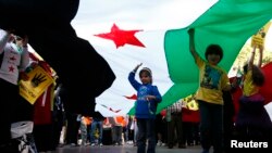 Children hold up a Syrian Opposition flag during a rally against the government of Syria and Egypt in central Sydney, Sept. 1, 2013. 