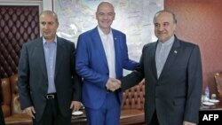 Iran's Minister of Sport and Youth Masoud Soltanifar, right, shakes hands with FIFA President Gianni Infantino during his visit to Tehran, March 1, 2018, accompanied by Iranian Football Federation President Mehdi Taj.