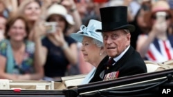 FILE - In this June 17, 2017 file photo, Britain's Queen Elizabeth II and Prince Philip return to Buckingham Palace in a carriage, after attending the annual Trooping the Colour Ceremony in London. 