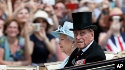 FILE - In this June 17, 2017 file photo, Britain's Queen Elizabeth II and Prince Philip return to Buckingham Palace in a carriage, after attending the annual Trooping the Colour Ceremony in London. 