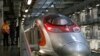 FILE - Crew members chat beside a Guangzhou-Shenzhen-Hong Kong Express Rail train stations at a depot in Hong Kong, China August 16, 2018.