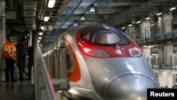 FILE - Crew members chat beside a Guangzhou-Shenzhen-Hong Kong Express Rail train stations at a depot in Hong Kong, China August 16, 2018.