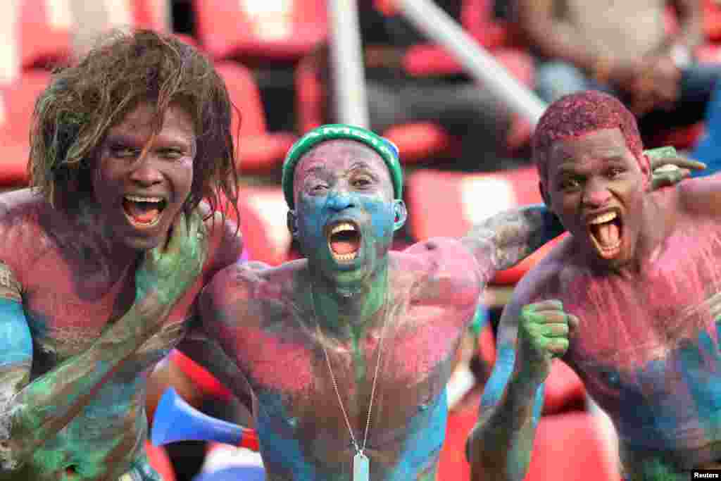 Gambia fans wear body paint in the stands before the match.