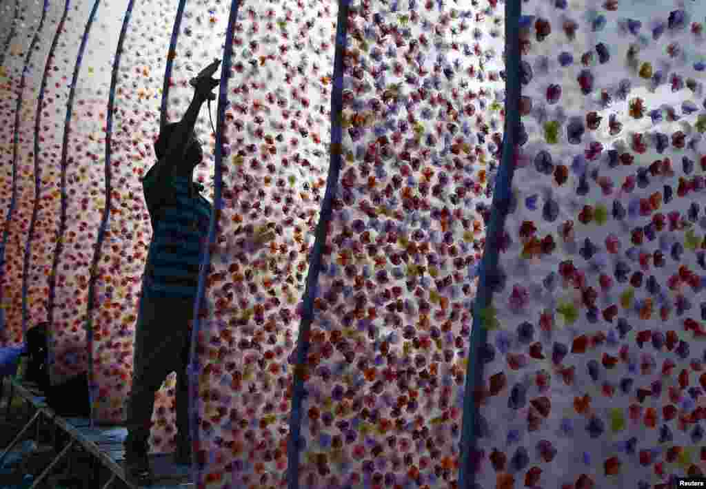 A man works on a Pandal, a temporary platform, being built for the Durga Puja festival, in Kolkata, India. The festival will be celebrated from Sept. 30 to Oct. 3, and is the biggest religious event for Bengali Hindus. 