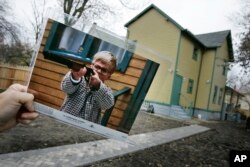 FILE - A photo of the character Ralphie, played by actor Peter Billingsley, firing his Red Ryder air rifle from the classic movie "A Christmas Story," is seen in the back yard of the house used in the filming of the movie in Cleveland, Nov. 13, 2006. The house was turned into a museum.