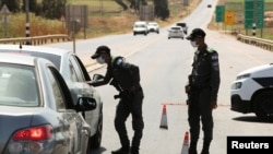 Israeli security force members stop a car as part of search efforts to capture six Palestinian men who escaped from Gilboa prison earlier this week, by the village of Muqeibila near the entrance to the Israeli-occupied West Bank, September 9, 2021.