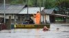 Agentes de policía revisan una casa mientras habitantes vadean una calle inundada por tormentas derivadas de un ciclón en Passo Fundo, en el estado de Rio Grande do Sul, Brasil, el 4 de septiembre de 2023.