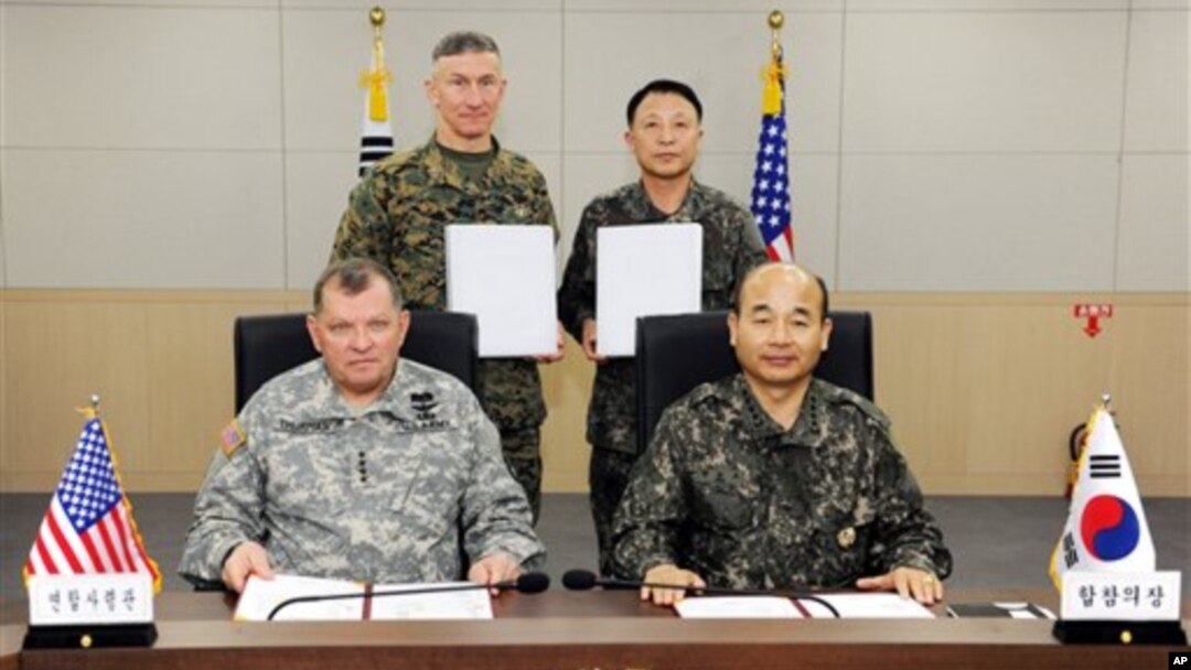 Ketua Dewan Kepala Staf Angkatan Bersenjata Korea Selatan Jung Seun-jo (kanan) dan panglima pasukan Amerika di Korea Selatan, Jenderal James Thurman berpose seusai penandatanganan kesepakatan militer si Seoul, Korea Selatan (22/3).
