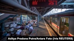 Para jemaah salat Idulfitri di peron stasiun kereta, di Jakarta, Kamis, 13 Mei 2021. (Foto: Aditya Pradana Putra/Antara Foto via Reuters)