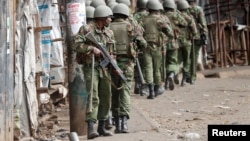 Kenyan police walk during clashes with supporters of opposition leader Raila Odinga, in Kibera slum, Nairobi, Kenya, Aug. 12, 2017. 