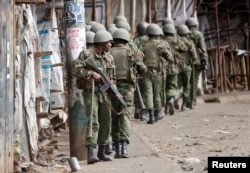 Kenyan police walk during clashes with supporters of opposition leader Raila Odinga, in Kibera slum, Nairobi, Kenya, Aug. 12, 2017.