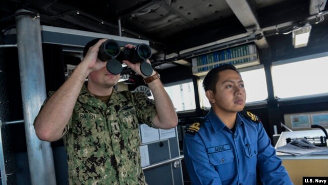 美国海军少尉拉兰和文莱海军少尉加平在美国海军的远征快速运输船上参加卡拉联合演习中的海上搜索行动