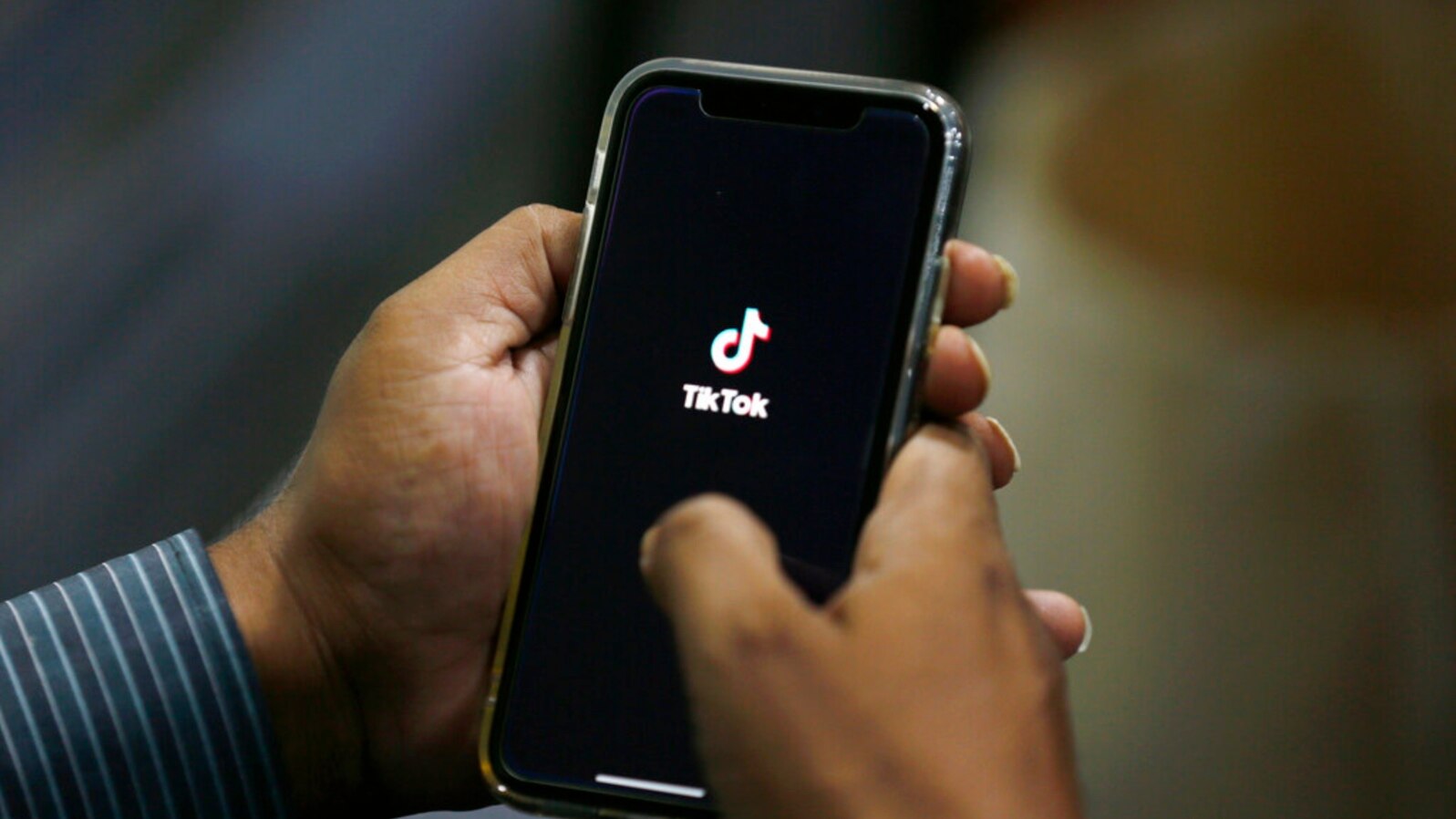 FILE - A man opens social media app TikTok on his cellphone in Islamabad, Pakistan, July 21, 2020. The government has blocked the video-sharing app several times in recent years over content moderation.