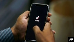 FILE - A man opens social media app TikTok on his cellphone in Islamabad, Pakistan, July 21, 2020. The government has blocked the video-sharing app several times in recent years over content moderation.