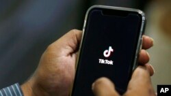 পাকিস্তানে এক ব্যক্তি তার মুঠোফোনে টিকটক দেখার চেষ্টা করছে।  ২১ জুলাই, ২০২০। ফাইল ছবি।