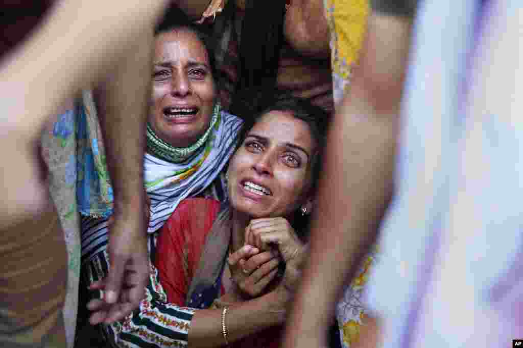 Aradhana, center, wife of Deepak Chand, a school teacher who was killed in Kashmir, mourns before the cremation in Jammu, India.